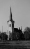 1910. aasta tulekahjule järgnes uue, tänini püsinud massiivtorni ehitamine (neogooti projekti järgi 1911-12. aastal, arhitekt F. Modi). Torni iseloomustavad nurkadest diagonaalselt eenduvad astmelised tugipiilarid, mis lõpevad miniatuurse tornikese ja neid ühendava frontooniga.. Foto: A. Alla, 1956.a. Ajaloomuuseumi fotoarhiiv, säilik F-16354.
